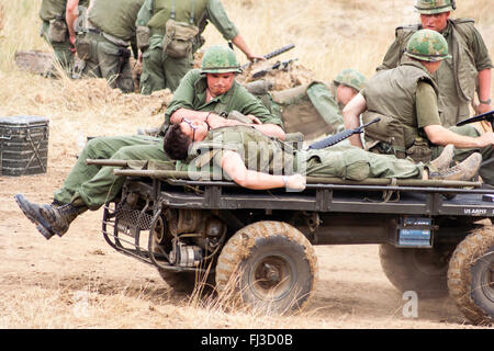 Re-enactment der Vietnam Krieg kämpfen. American Marine resuscitates verwundete Soldaten erschossen wurde, während Sie weg von der Battle Zone gefahren wird. Stockfoto