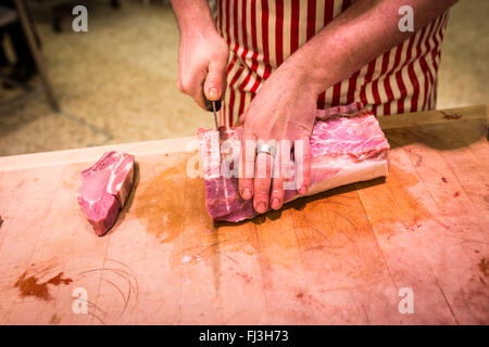 Nahaufnahme eines Metzgers hacken Fleisch auf einem Schneidebrett Stockfoto