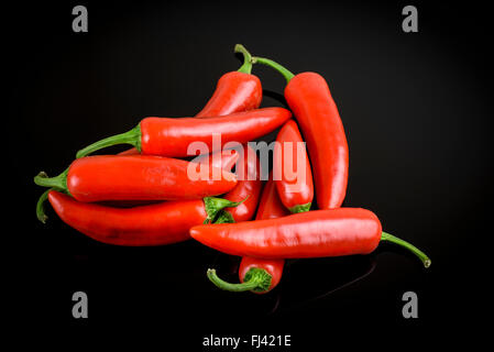 Gruppe von frische ganze Red Hot Chili auf schwarzem Hintergrund Stockfoto