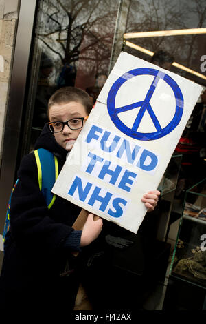 Trident-Demonstration organisiert von CND zu stoppen. Ein kleiner Junge hält ein Plakat sagt, "Die NHS mit CND Symbol zu finanzieren". Stockfoto