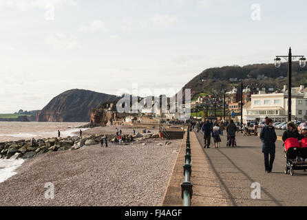 Blick auf Sidmouth Küste und Stadt mit Menschen zu Fuß am Strand mit Felsen im Hintergrund. Stockfoto