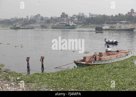 Bangladeshi Arbeiter entladen Ziegel von einem Boot auf dem Fluss Buriganga, Dhaka, Bangladesh. Flusses Buriganga ist eines der am stärksten verschmutzten und biologisch tot Fluss der Welt. 29. Februar 2016. © Suvra Kanti Das/ZUMA Draht/Alamy Live-Nachrichten Stockfoto