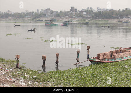 Bangladeshi Arbeiter entladen Ziegel von einem Boot auf dem Fluss Buriganga, Dhaka, Bangladesh. Flusses Buriganga ist eines der am stärksten verschmutzten und biologisch tot Fluss der Welt. 29. Februar 2016. © Suvra Kanti Das/ZUMA Draht/Alamy Live-Nachrichten Stockfoto