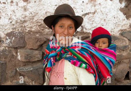 Frau in traditioneller Kleidung Huckepack tragen ihr Baby im Tragetuch, Porträt, Peru, Pisaq Stockfoto