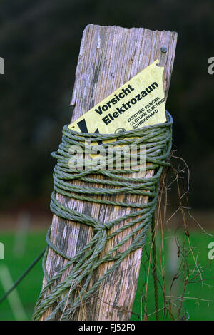 Elektrozaun mit Warnschild an Holzpfosten, Deutschland Stockfoto
