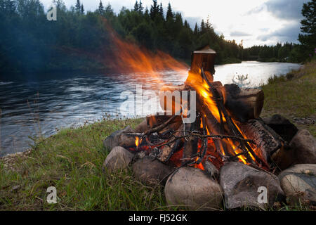 Lagerfeuer am Flussufer, Schweden Stockfoto