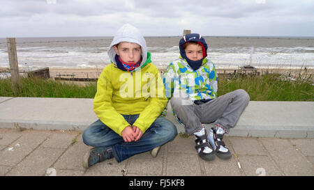 zwei coole Jungs sitzen zusammen an der Nordsee Küste, Niederlande Stockfoto