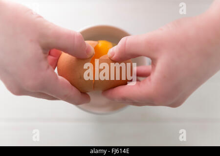 Ein Koch, eine Freilandhaltung Ei in einer Schüssel zu knacken. Stockfoto