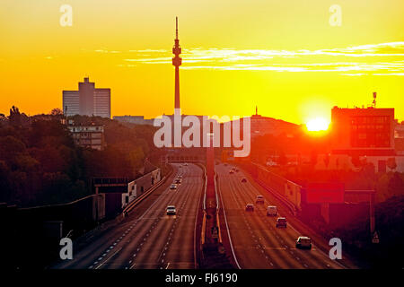 Autobahn A 40 bei Sonnenaufgang mit Florianturm und Westfalenhallen Dortmund, Deutschland, Nordrhein-Westfalen, Ruhrgebiet, Dortmund Stockfoto