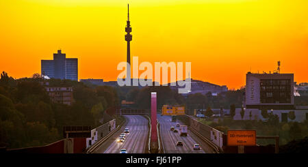 Autobahn A 40 vor Sonnenaufgang mit Florianturm und Westfalenhallen Dortmund, Deutschland, Nordrhein-Westfalen, Ruhrgebiet, Dortmund Stockfoto