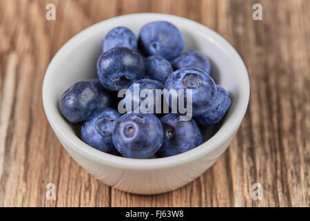 Super Essen Heidelbeeren in eine weiße Tasse auf einem braunen Holztisch Stockfoto