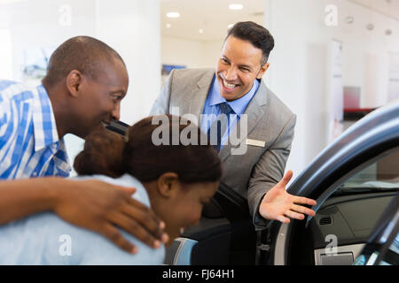 freundliche Händler Verkauf von Neuwagen, junges Paar im showroom Stockfoto