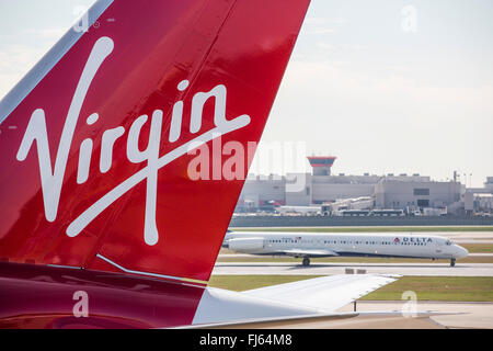 Ein Delta Airline Flugzeug landet hinter Virgin Atlantic Flugzeug auf der Landebahn am Hartsfield-Jackson Atlanta International Airport. Stockfoto