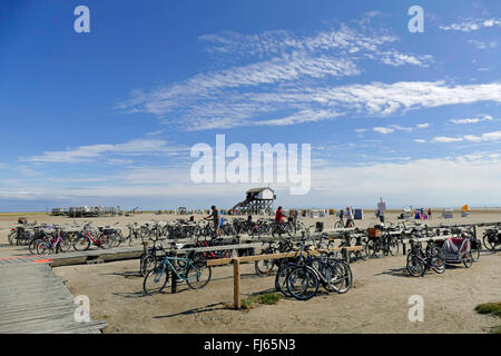 geparkte Fahrräder am Strand, Pfahlbauten und Plattform für Strandkörbe im Hintergrund, Northern Frisia, Sankt Peter-Ording Stockfoto