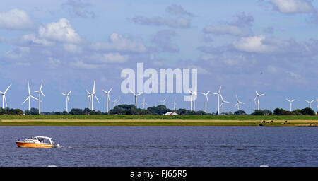 Motorboot am Fluss Eider, Windkraftanlagen im Hintergrund, Deutschland, Schleswig-Holstein, Tönning Stockfoto