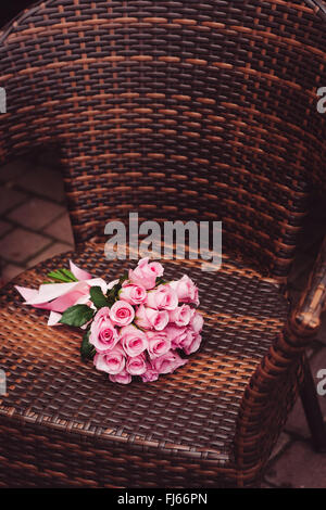 Rosa Rosen auf Stuhl für Datum Stockfoto