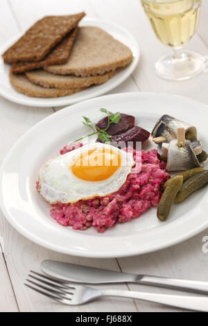 Labskaus mit Spiegelei, saure Gurke, rote Beete und rollmops Stockfoto