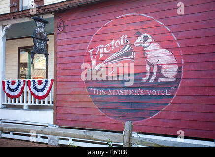 Bilder von einem und dem gemalten "Victor"-Logo und einen Zaun mit Bunting über einen Shop, der Holzöfen in St. Augustine Florida verkauft, USA Stockfoto