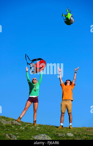 zwei junge Menschen werfen sich vor Freude ihren Rucksäcken, Frankreich, Savoie Stockfoto