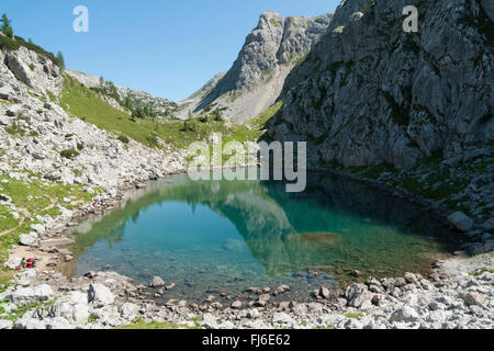 Wanderer ruht auf See Seleinsee in den Bergen des Nationalparks Berchtesgaden an einem sonnigen Sommertag, Bayern, Deutschland Stockfoto