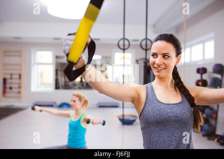 Frau im Fitness-Studio Training Arme mit Trx-Fitness-Streifen Stockfoto