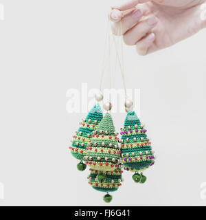 Hand mit Christbaumkugeln vor einem weißen Hintergrund abgeschnitten Stockfoto