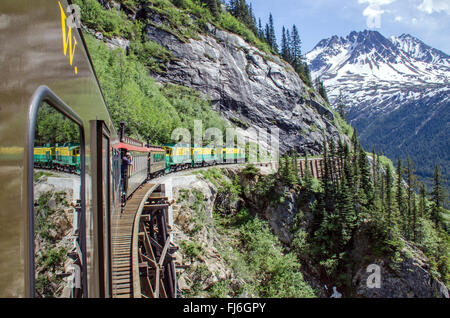 White Pass & Yukon Route Railroad reist entlang der Klippen Richtung Skagway, Alaska Stockfoto