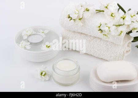 Spa und Wellness-Einstellung, Kerze, Blumen und Handtücher, Seife, Bodylotion Stockfoto