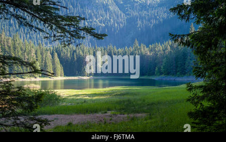 Bergsee im Rahmen der Bäume am Abend Sonnenlicht Stockfoto