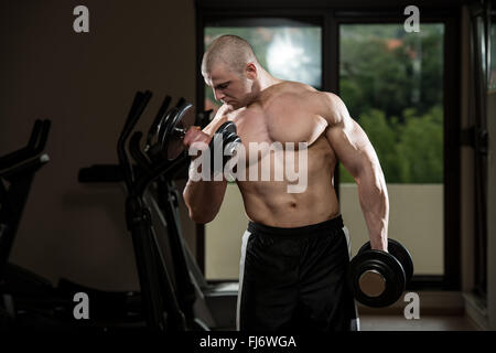 Bodybuilder, die schwere Übung für Bizeps mit Hanteln im Fitnessstudio Stockfoto