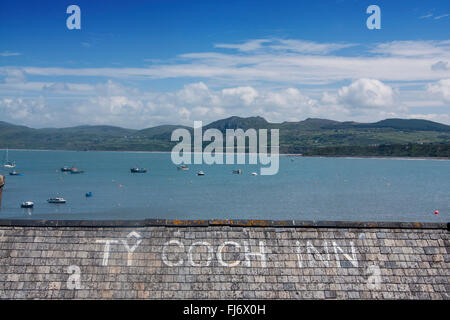 Porth Dinllaen Ty Coch Inn Pub Schiefer geflieste Dach und Blick über Hafen, Boote und Berge Cardigan Halbinsel Gwynedd North Wales UK Stockfoto