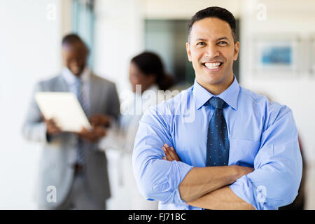 gut aussehende corporate Arbeitnehmer in modernen Büro mit Kollegen im Hintergrund Stockfoto