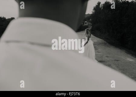 Braut führt Bräutigam, auf der Straße Stockfoto