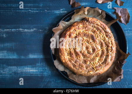 Frisch zubereitet und gebacken doppelter Käsekuchen auf blauen hölzernen Hintergrund mit Textfreiraum Stockfoto