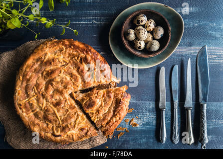 Frisch zubereitet und gebacken doppelter Käsekuchen auf blauen hölzernen Hintergrund mit Wachteleiern, Ostern-Konzept Stockfoto