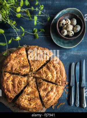 Frisch zubereitet und in Scheiben geschnittenen doppelter Käsekuchen und Wachteleiern auf hölzernen Hintergrund, Ostern-Küche Stockfoto