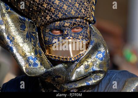 Ein Mann mit einer aufwendigen venezianische Maske und Kostüm während des jährlichen Karnevals von Venedig in Venedig, Italien. Karneval läuft offiziell für 10 Tage auf die christliche Feier der Fastenzeit endet. Stockfoto