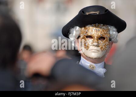 Ein Mann mit einer aufwendigen venezianische Maske und Kostüm während des jährlichen Karnevals von Venedig in Venedig, Italien. Karneval läuft offiziell für 10 Tage auf die christliche Feier der Fastenzeit endet. Stockfoto