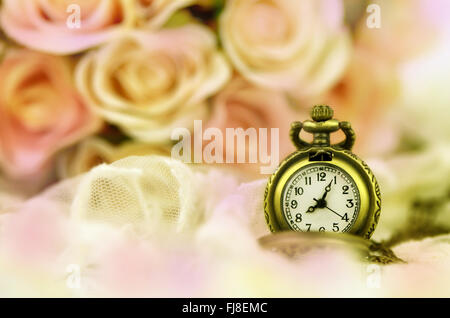 Vintage Taschenuhr mit rose Bouquet auf Pastell Ton Hintergrund. Stockfoto