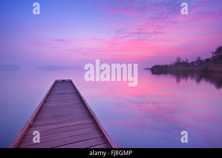 Ein kleiner Steg an einem noch See an einem ruhigen Morgen im Morgengrauen, in der Nähe von Amsterdam in den Niederlanden. Stockfoto