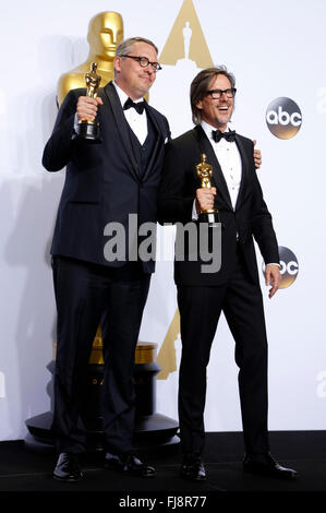 Schriftsteller Adam McKay (L) und Charles Randolph, Gewinner des Best Writing (adaptiertes Drehbuch) Award für "The Big Short" stellen im Presseraum während der 88. Annual Academy Awards im Loews Hollywood Hotel am 28. Februar 2016 in Hollywood, Kalifornien. Stockfoto