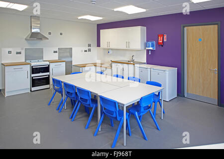Ein Hauswirtschaft Klassenzimmer in eine neue britische Grundschule. Zeigt Tabelle, Herde und Waschmaschinen Stockfoto