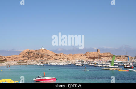 Ille Rousse, Korsika, Frankreich. Hafen und Leuchtturm auf diesen rote Felsen ausgesetzt. Stockfoto
