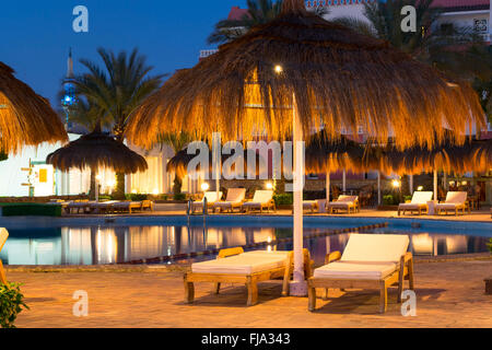 SHARM EL SHEIKH, Ägypten - 27. Februar 2014: Februar-Nacht am Strand, Stroh Sonnenschirmen und liegen am Pool im Hotel werden Stockfoto