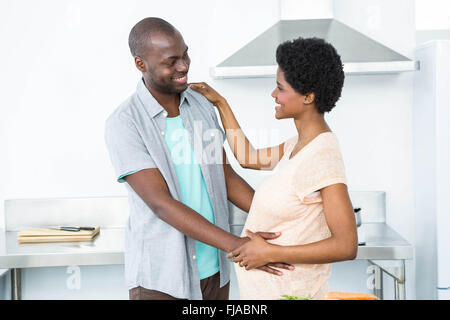 Schwangere paar kuscheln in Küche Stockfoto