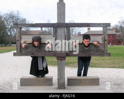 Ein Junge und ein Mädchen in der Aktien befindet sich etwas außerhalb des Gerichtsgebäudes in Colonial Williamsburg, Virginia. Stockfoto