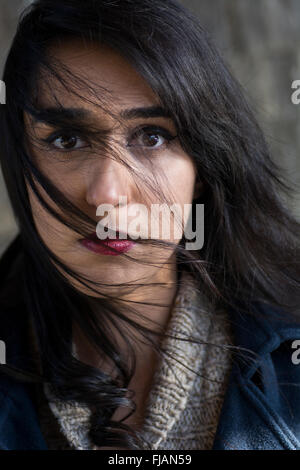 Ernste junge Frau Haar bedeckte Gesicht Stockfoto