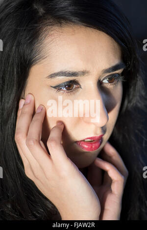 Nahaufnahme von einem besorgt junge Frau Hände berühren Gesicht im freien Stockfoto