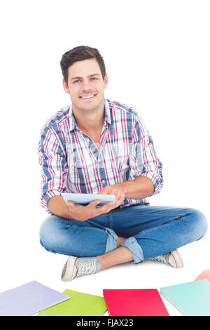 Mann mit einem Tablet auf dem Boden sitzend Stockfoto