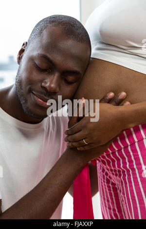 Mann schwanger Womans Magen anhören Stockfoto